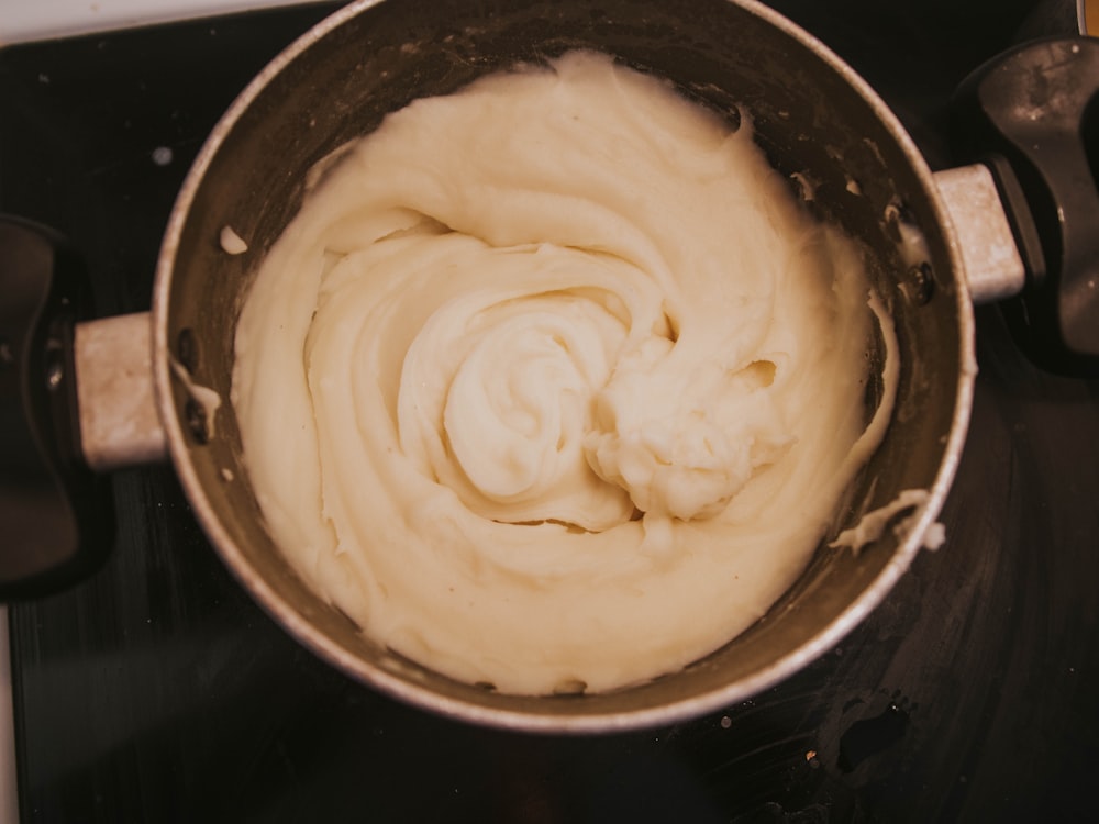a pot of cream sitting on top of a stove