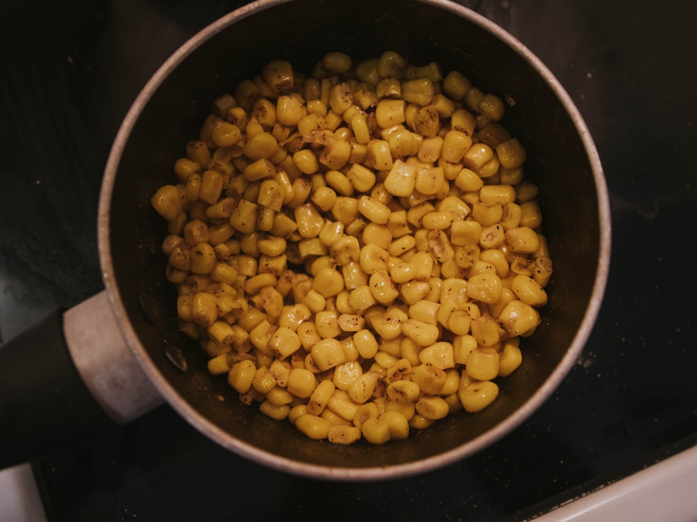 a pot filled with corn sitting on top of a stove