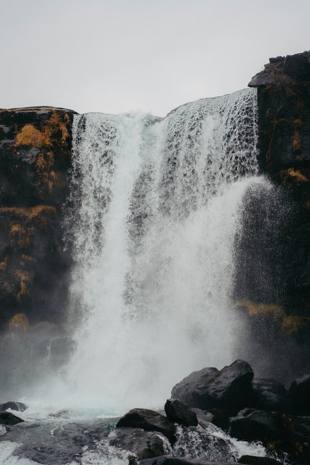 a man standing in front of a waterfall