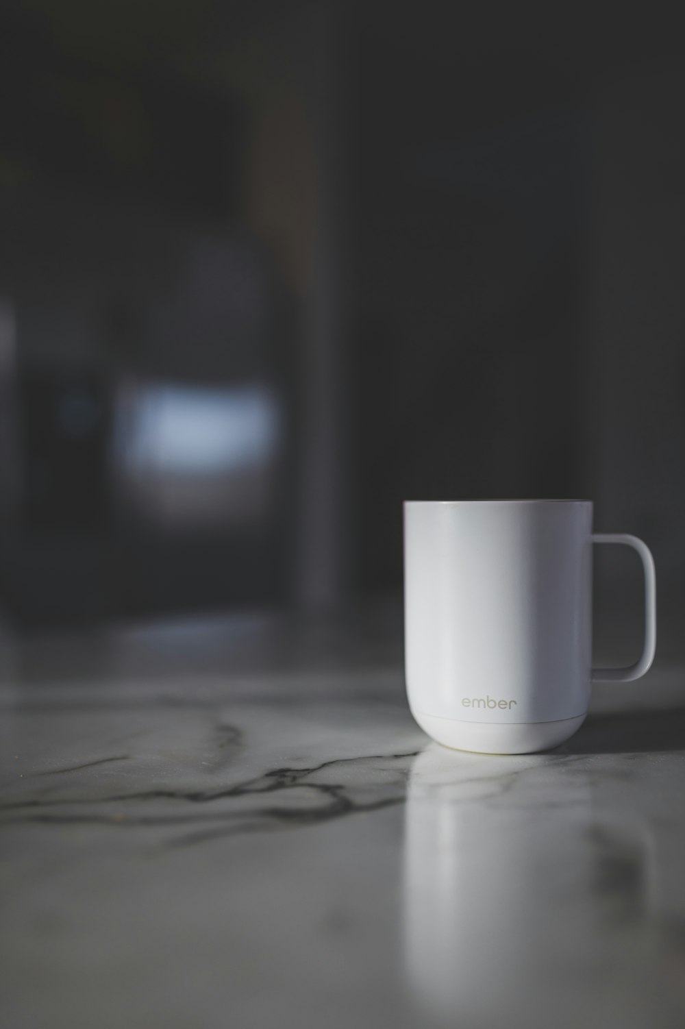 a white cup sitting on top of a marble counter