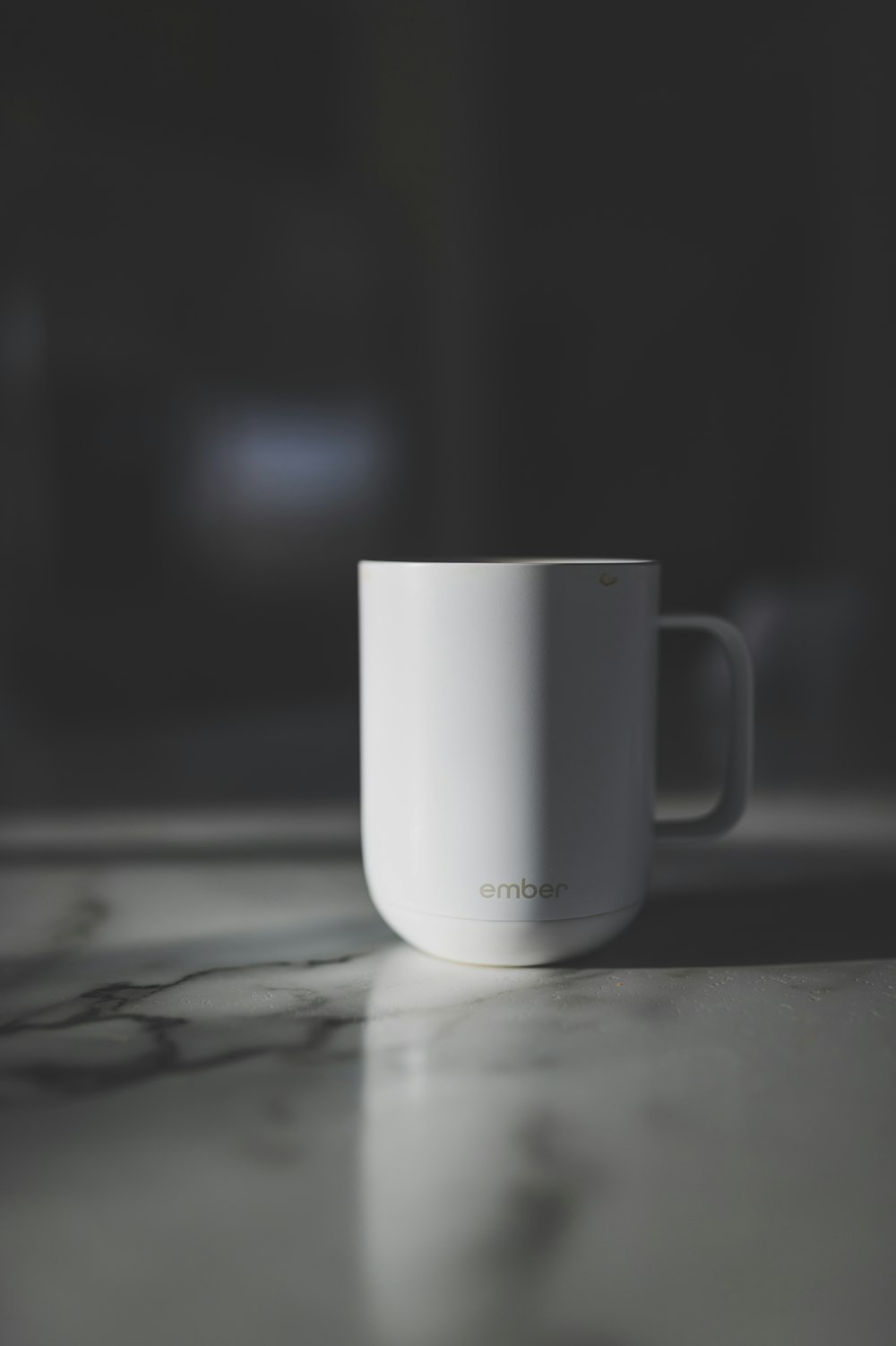 a white coffee cup sitting on top of a counter