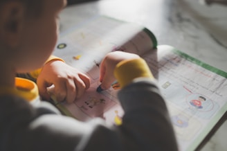 a young child is doing something on a piece of paper