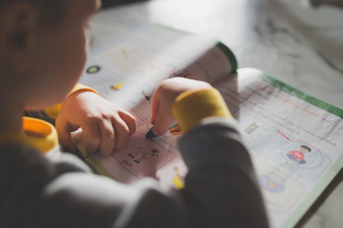 a young child is doing something on a piece of paper