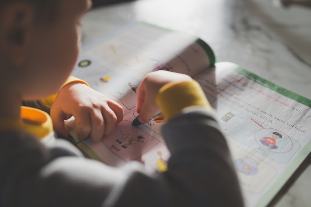 a young child is doing something on a piece of paper