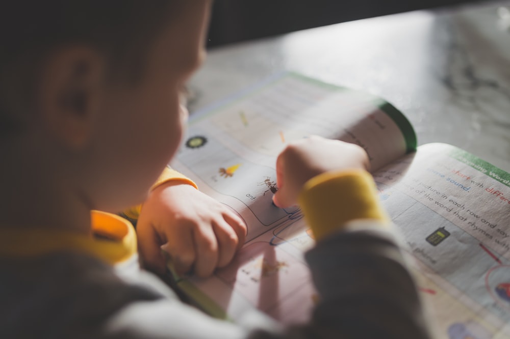 a young child is writing on a piece of paper