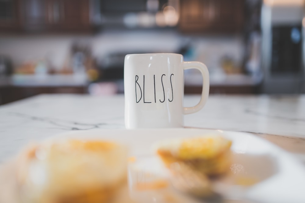 a white coffee mug sitting on top of a white plate