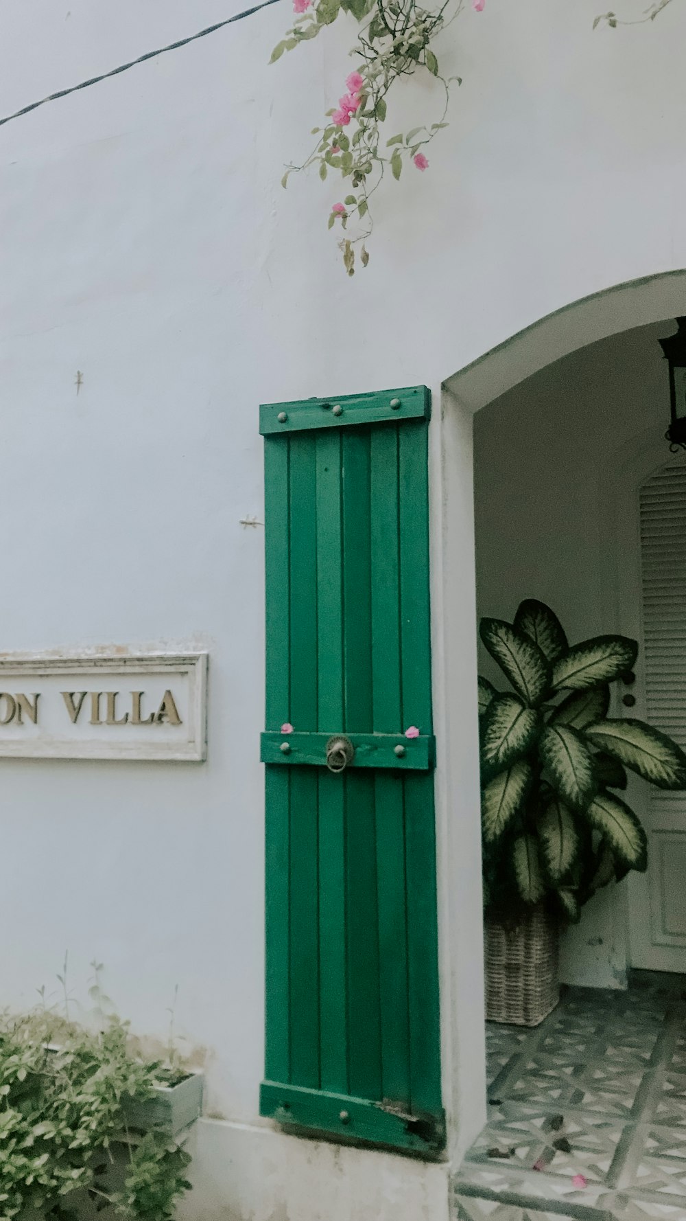 a white building with a green door and green shutters