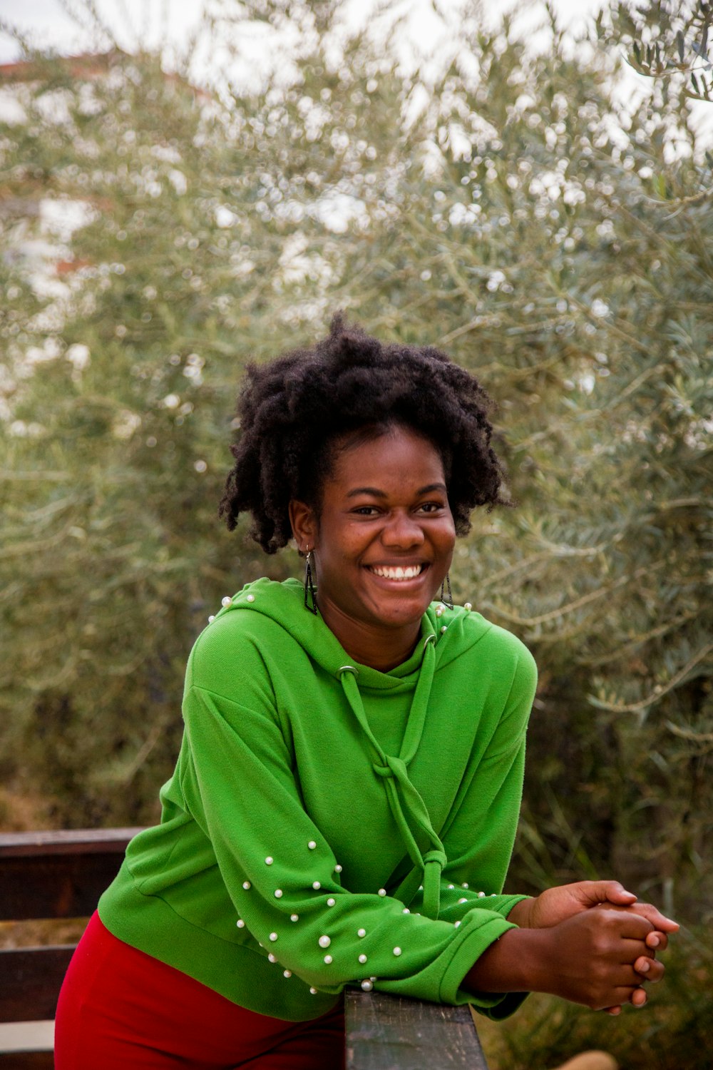 a woman sitting on a bench smiling for the camera