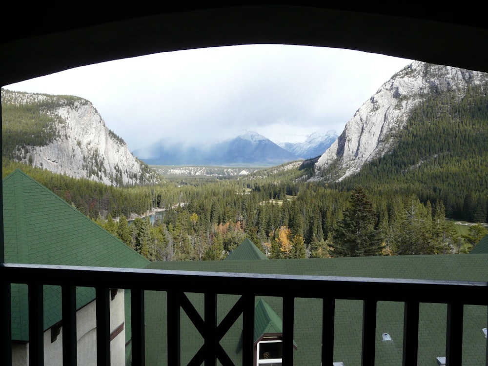 a balcony with a view of mountains and trees