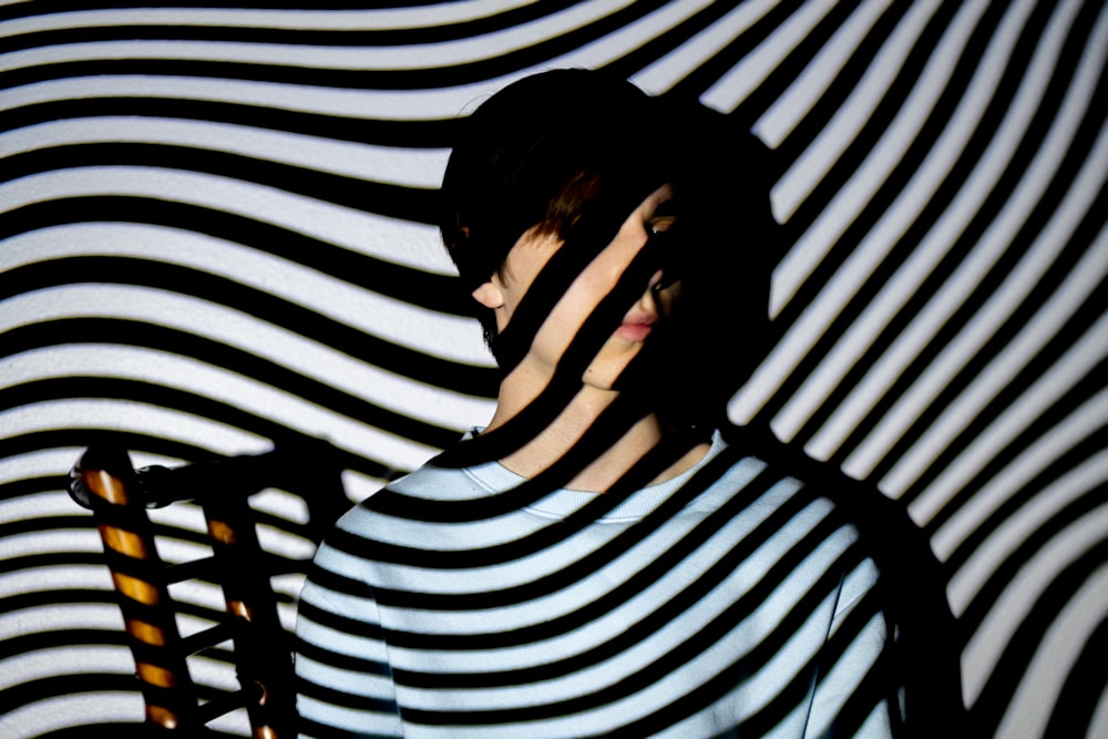 a woman standing in front of a striped wall