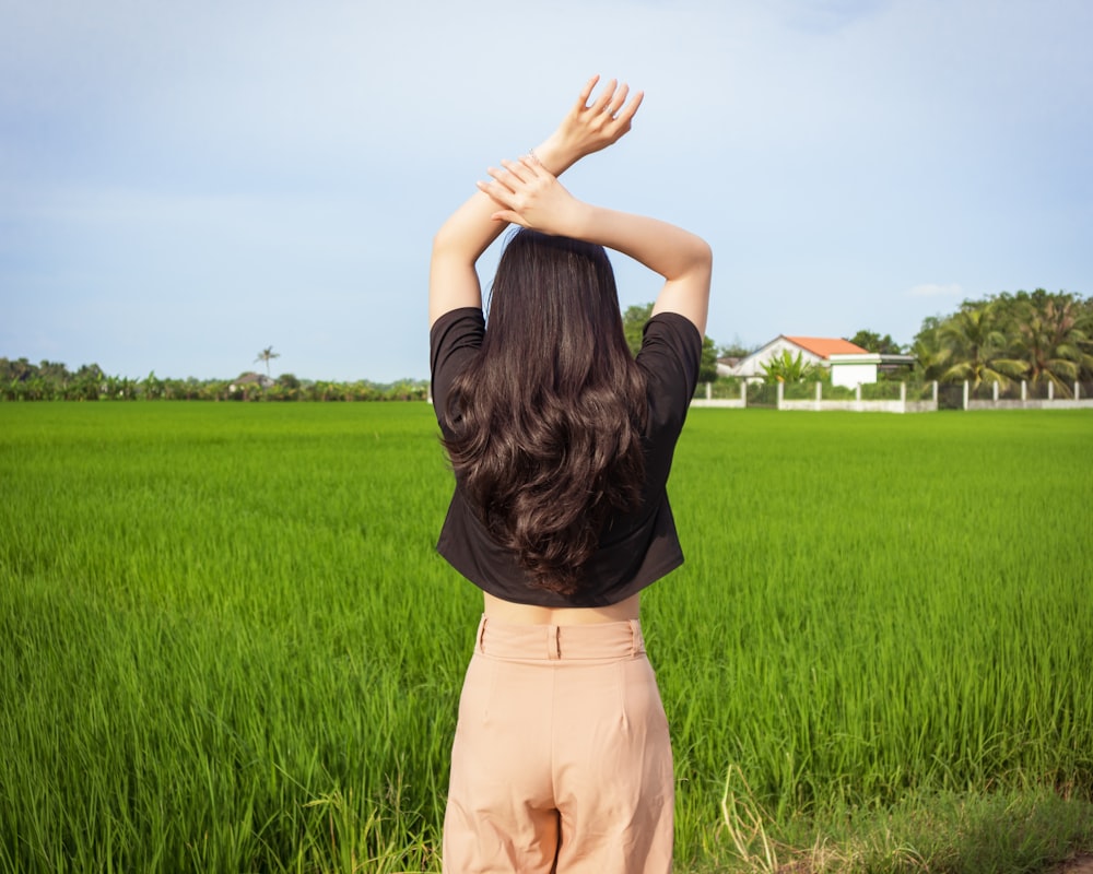 a woman standing in front of a lush green field