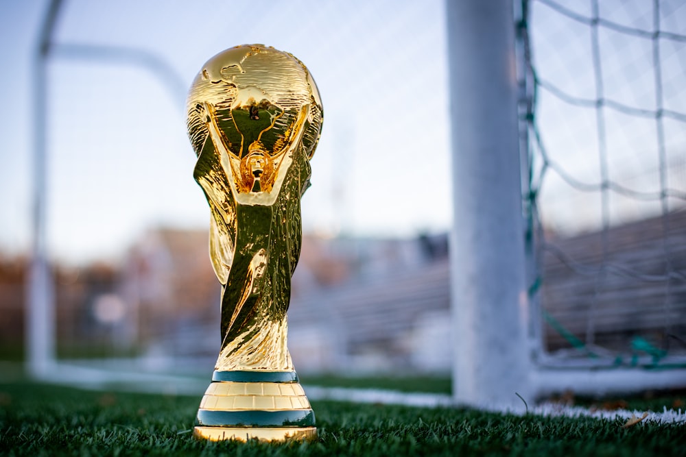 Un trofeo de fútbol dorado sentado en la parte superior de un campo