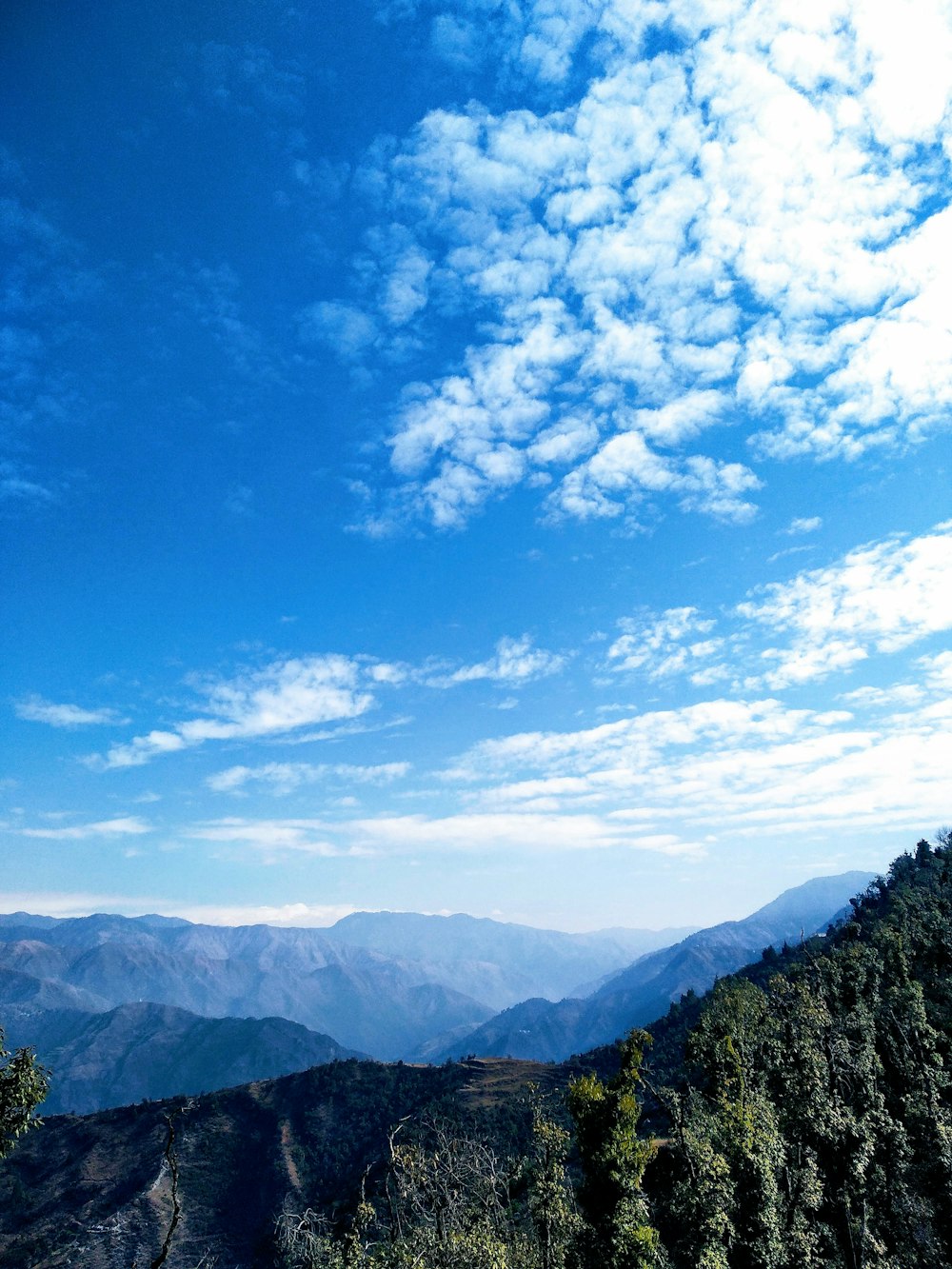 a scenic view of a mountain range under a blue sky