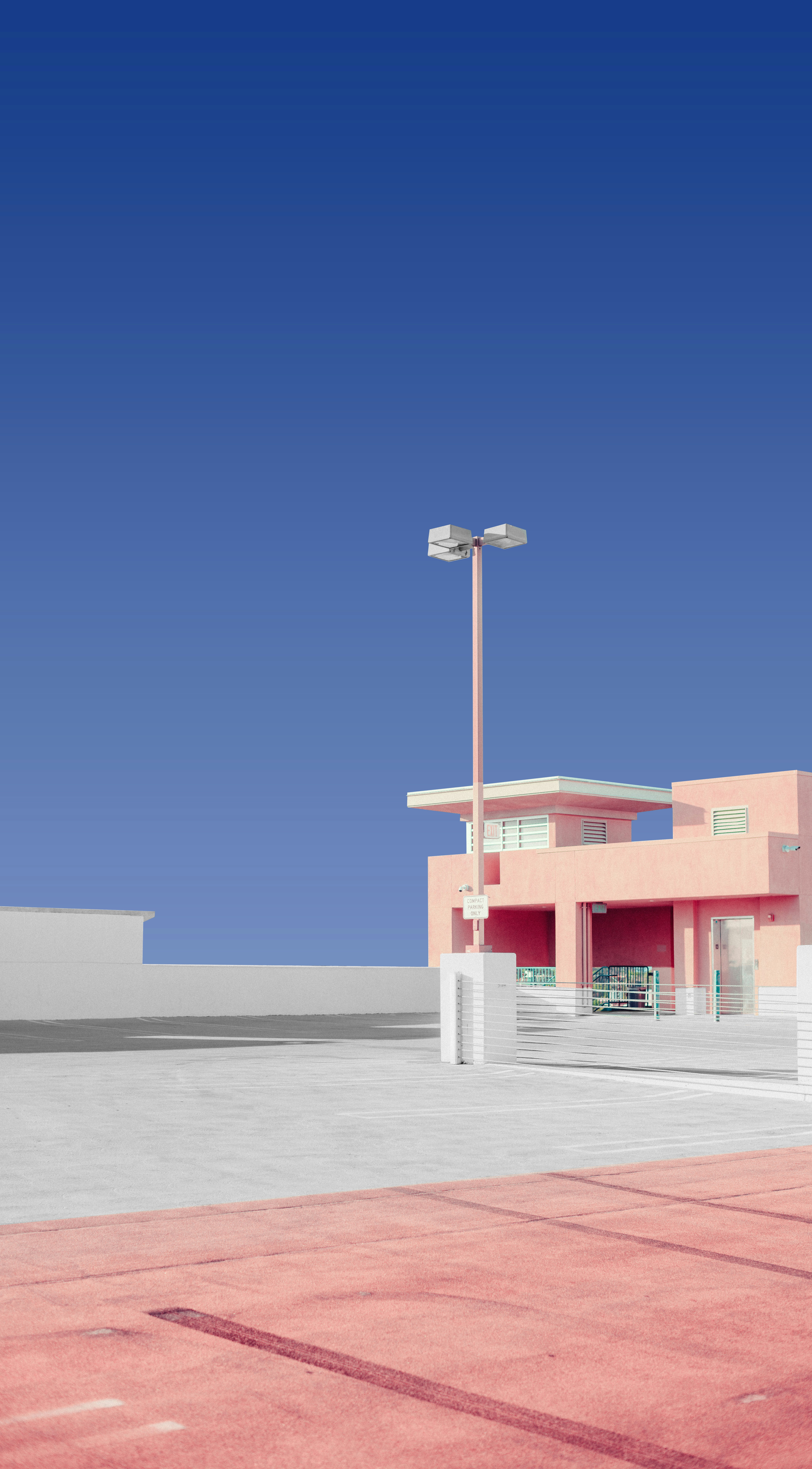 A pink building with a parking lot in front of it photo – Free Blue ...