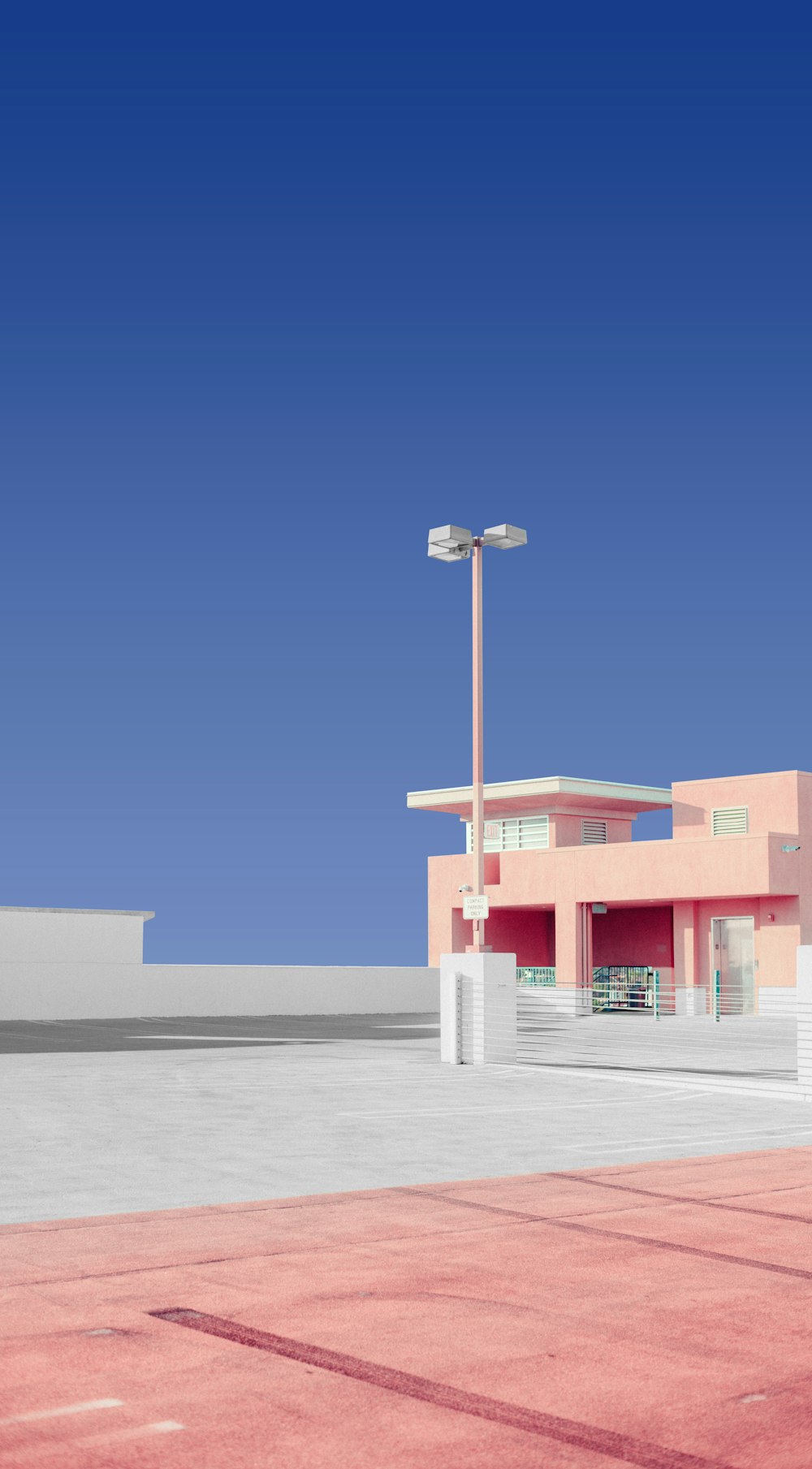 a pink building with a parking lot in front of it