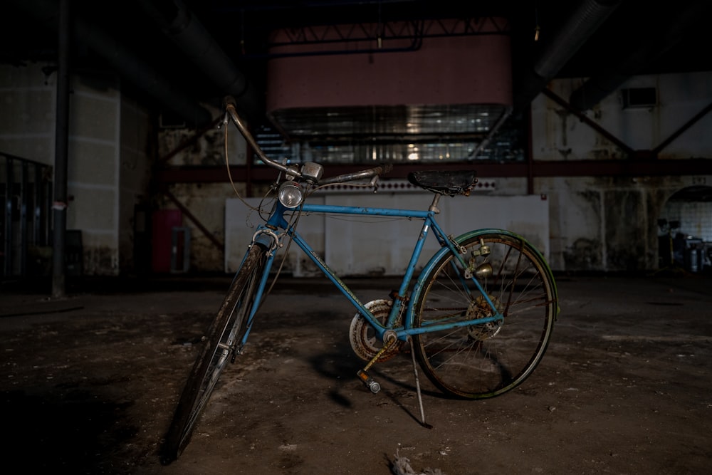 Un vélo bleu est garé dans un vieux bâtiment