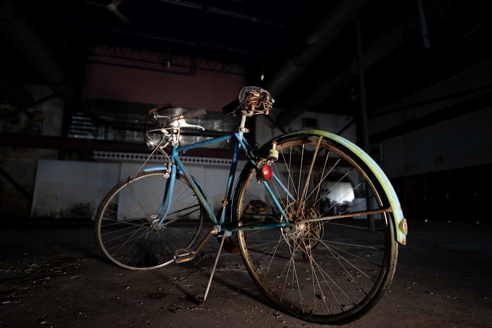 a blue bicycle parked in a dark room