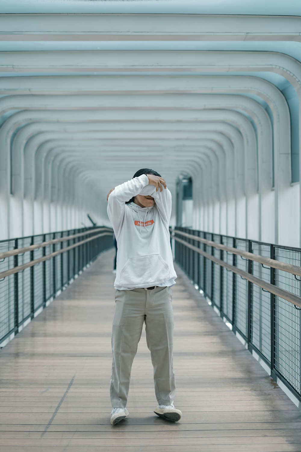 a man standing on a bridge with his head in his hands