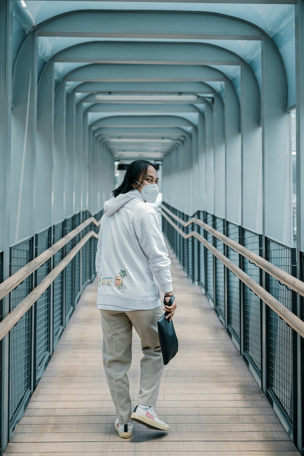 a woman is walking down a long walkway