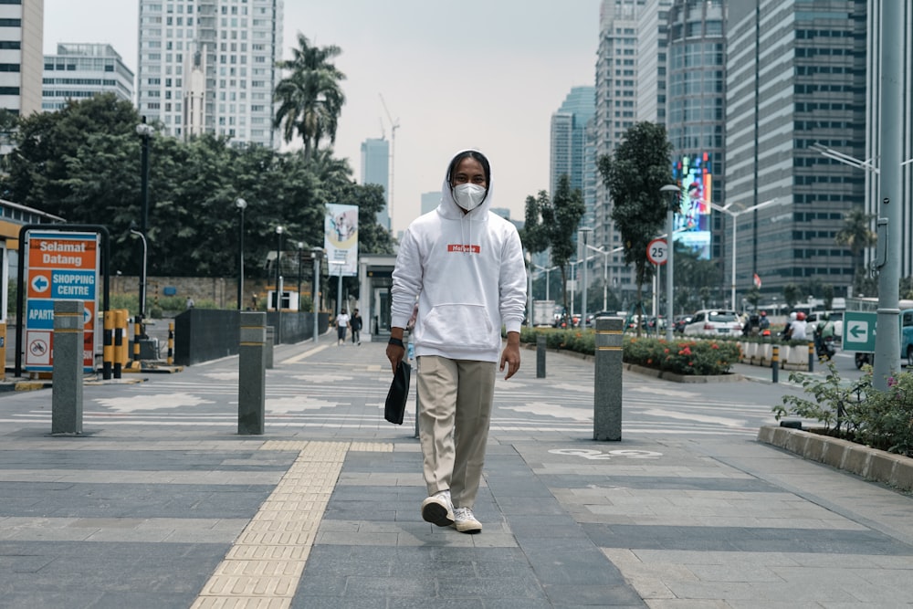 a man wearing a face mask walking down a street