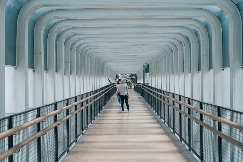a person walking down a long walkway with a sky background