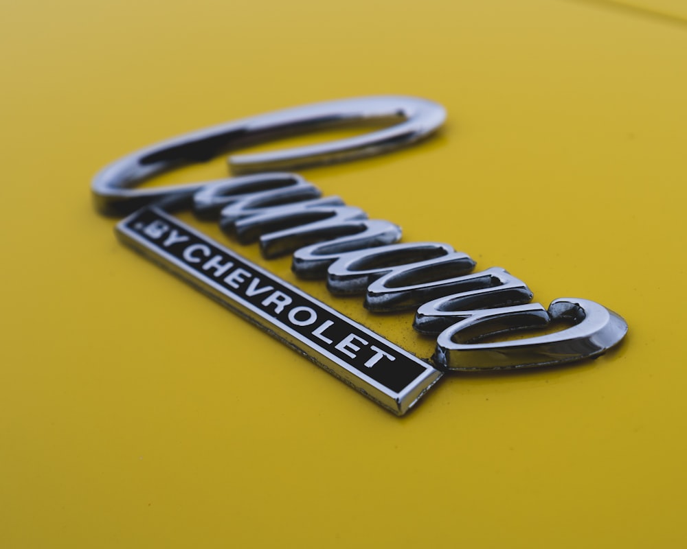 a close up of the emblem on a yellow car