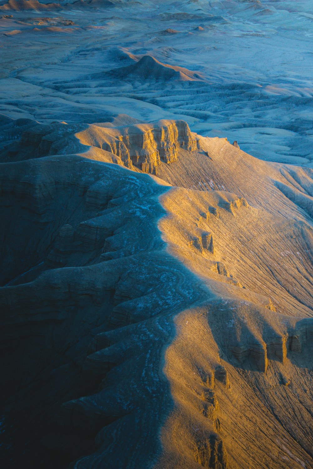 an aerial view of a mountain range at sunset