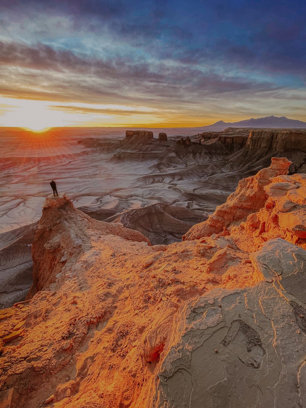 a person standing on top of a mountain at sunset