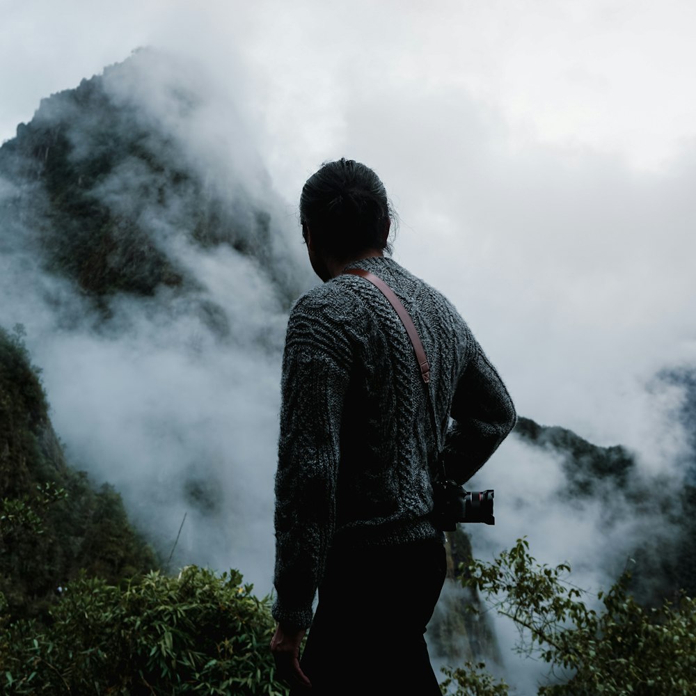 a man standing on top of a lush green hillside