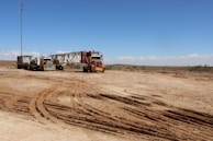 a couple of trucks that are sitting in the dirt