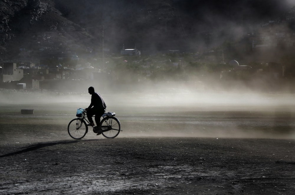 a person riding a bike on a foggy day