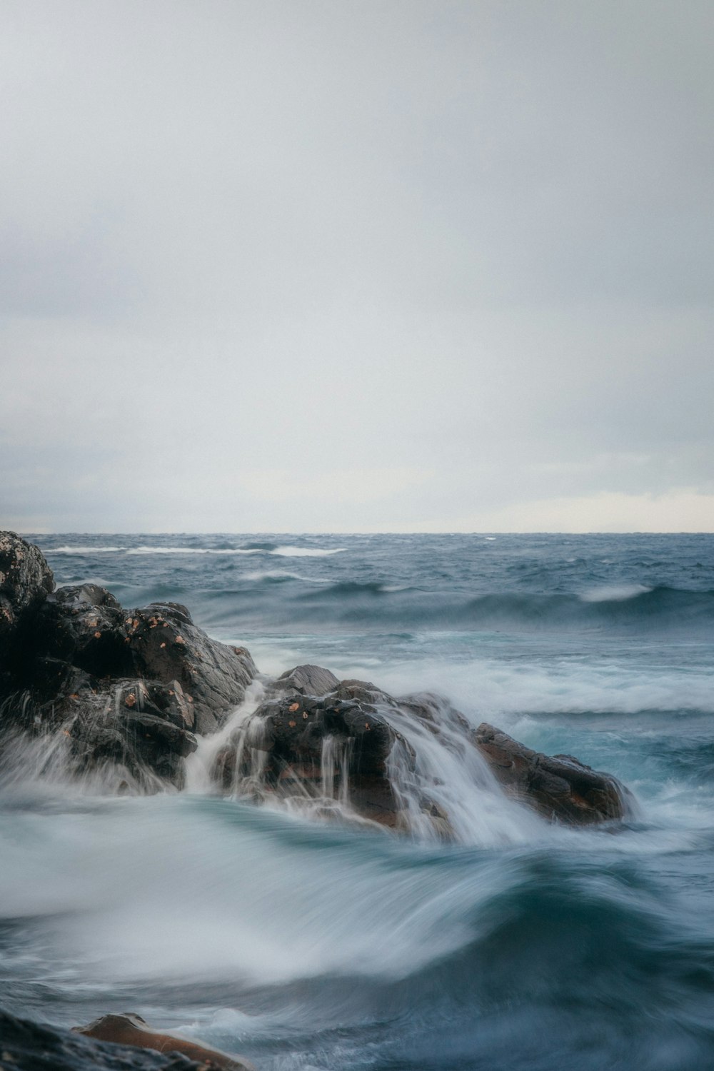 a large body of water next to a rocky shore