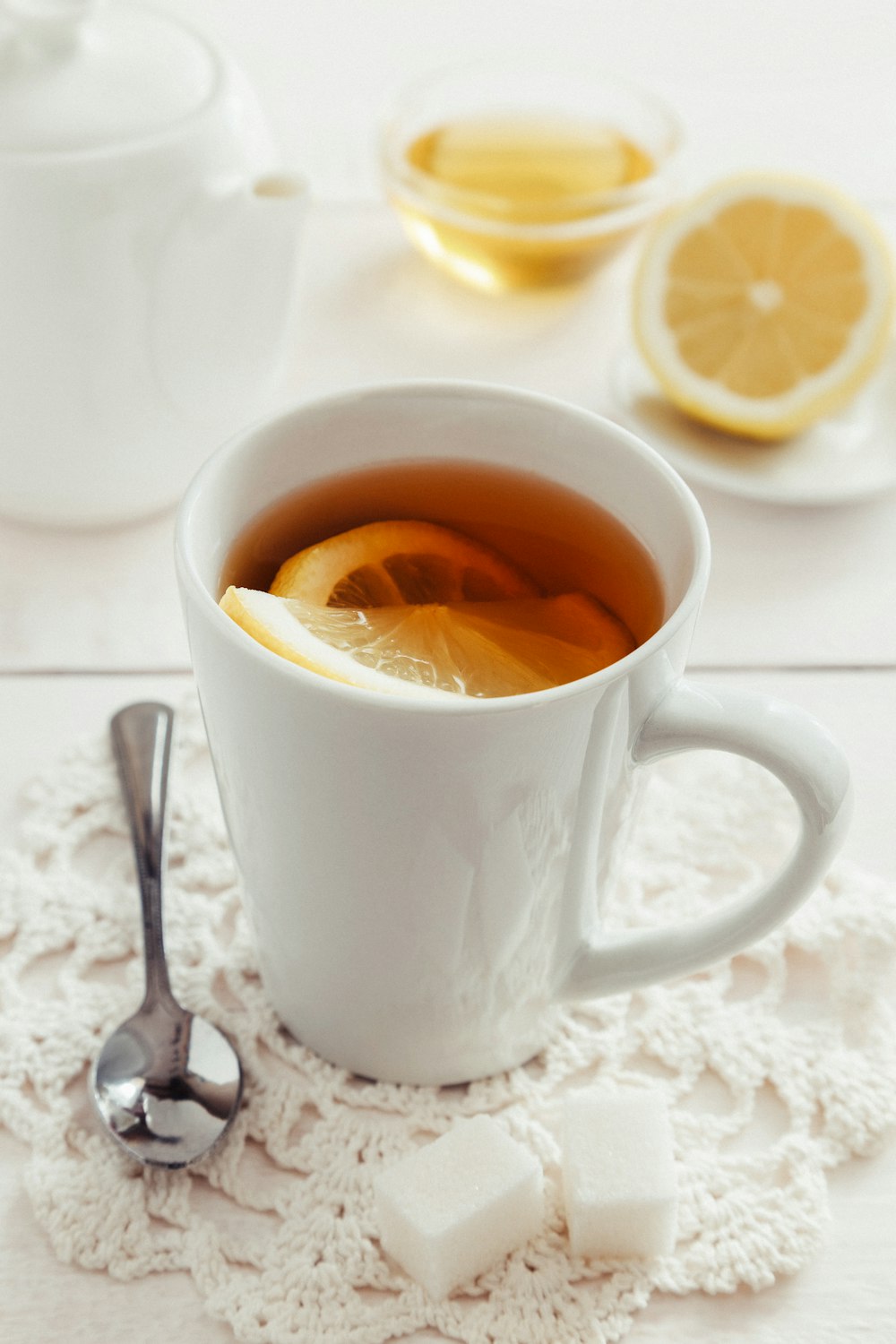 eine Tasse Tee mit einer Zitronenscheibe auf einem Mantel