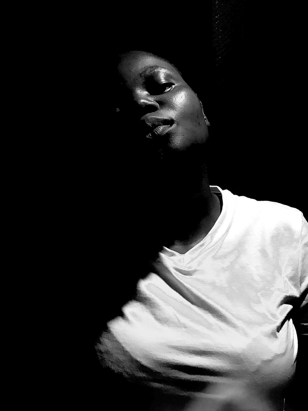 uma foto em preto e branco de uma mulher no escuro