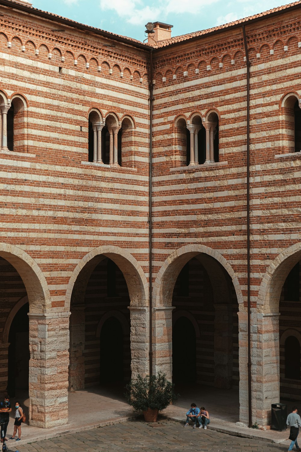 a group of people standing in front of a brick building