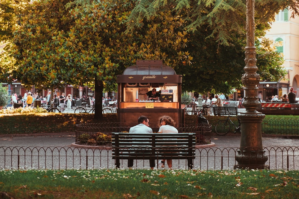 a couple sitting on a bench in a park