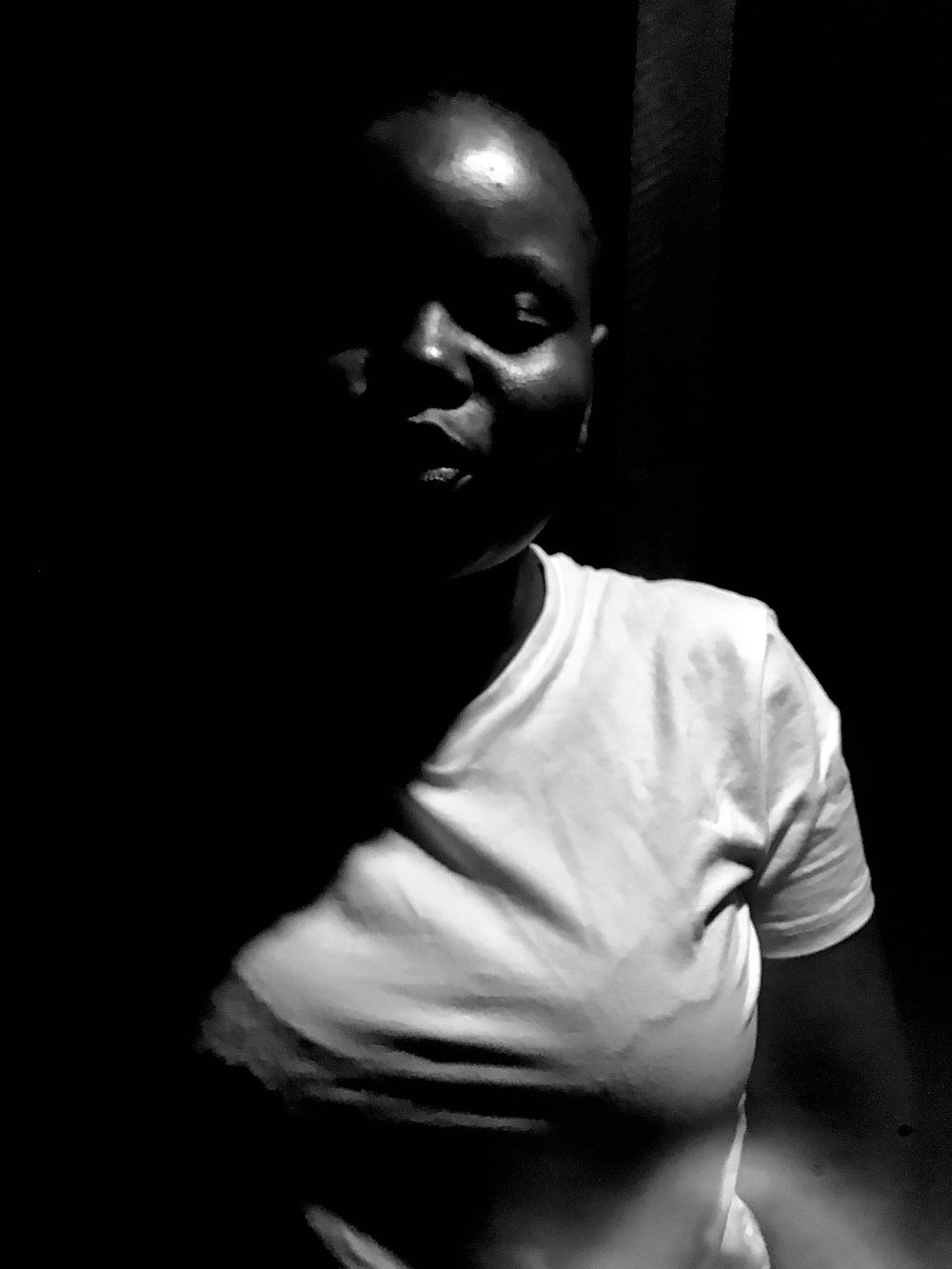 a black and white photo of a woman in a dark room