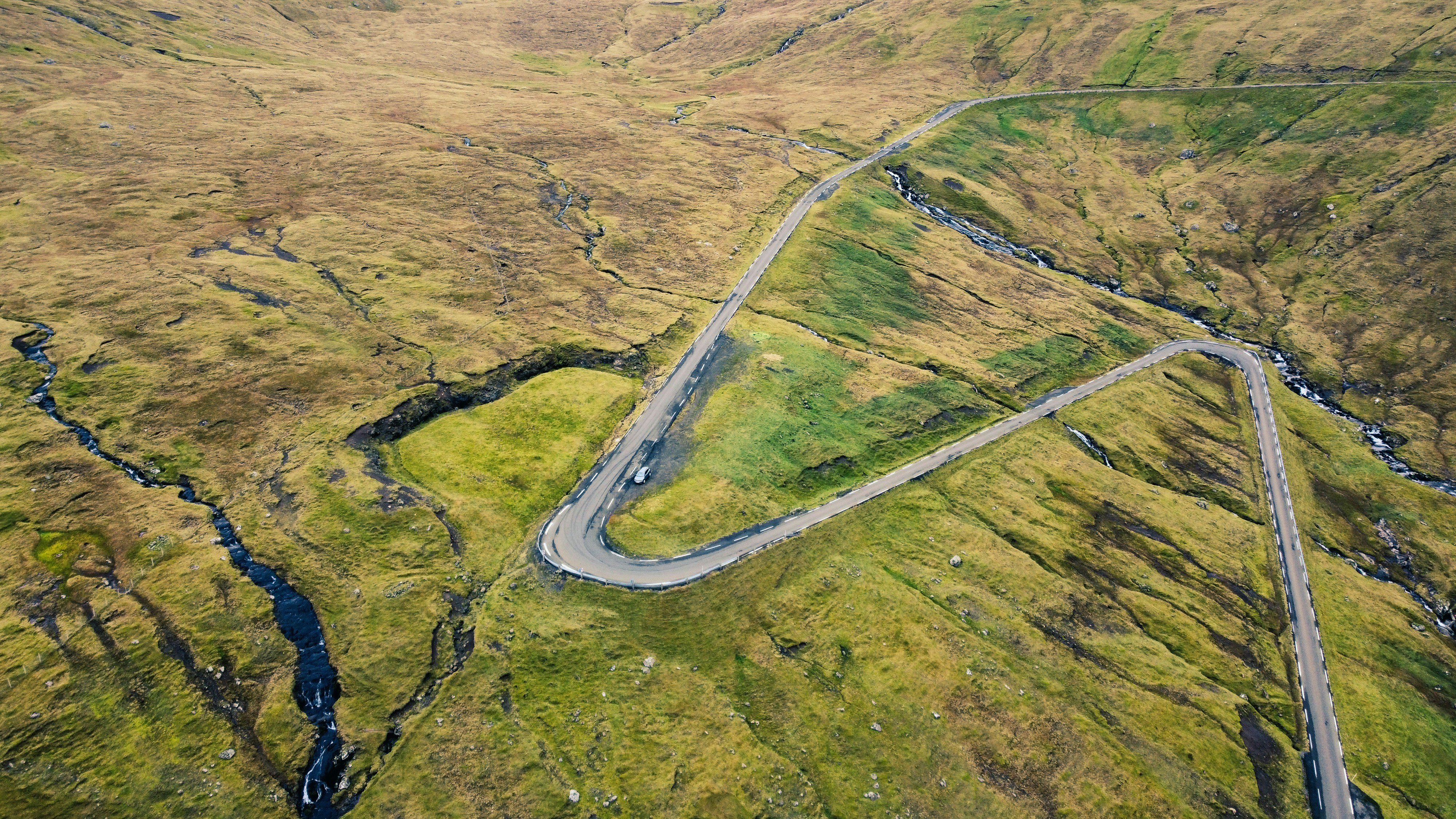 an aerial view of a winding road in the mountains
