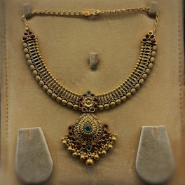 An elegant gold necklace adorned with intricate designs.
