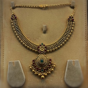 A stunning gold necklace adorned with intricate designs.
