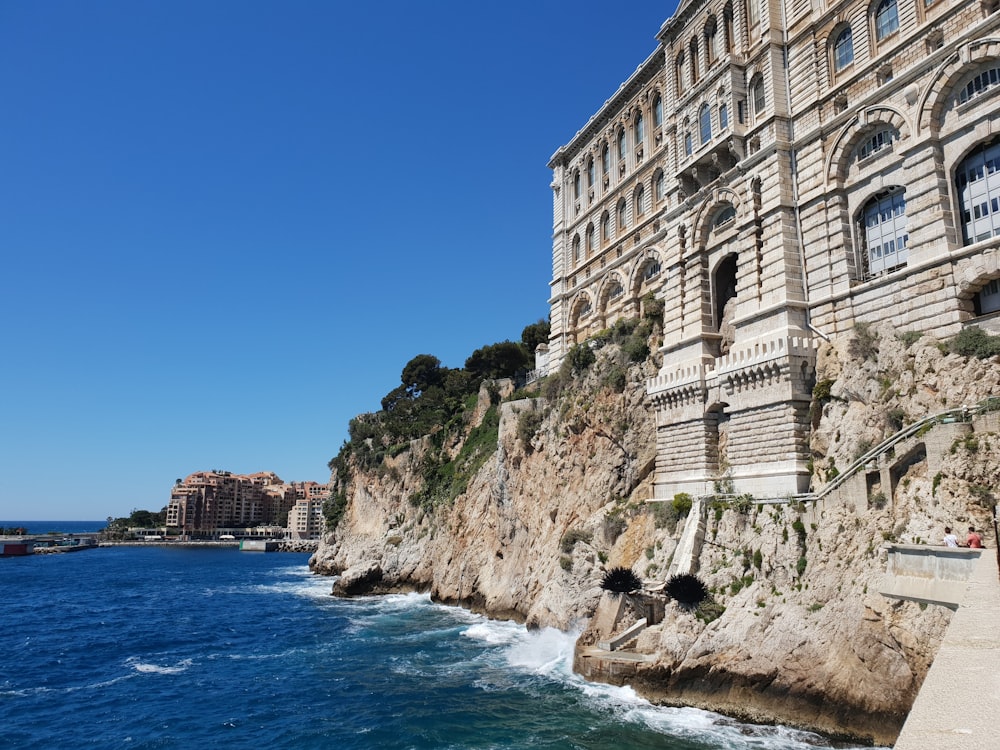 a large building on the side of a cliff next to the ocean