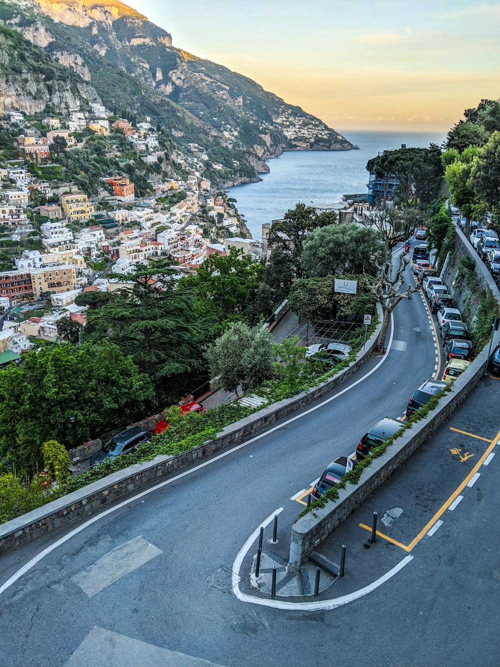 a winding road with cars parked along the side of it