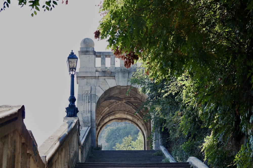 a stone stairway with a light post on the side of it