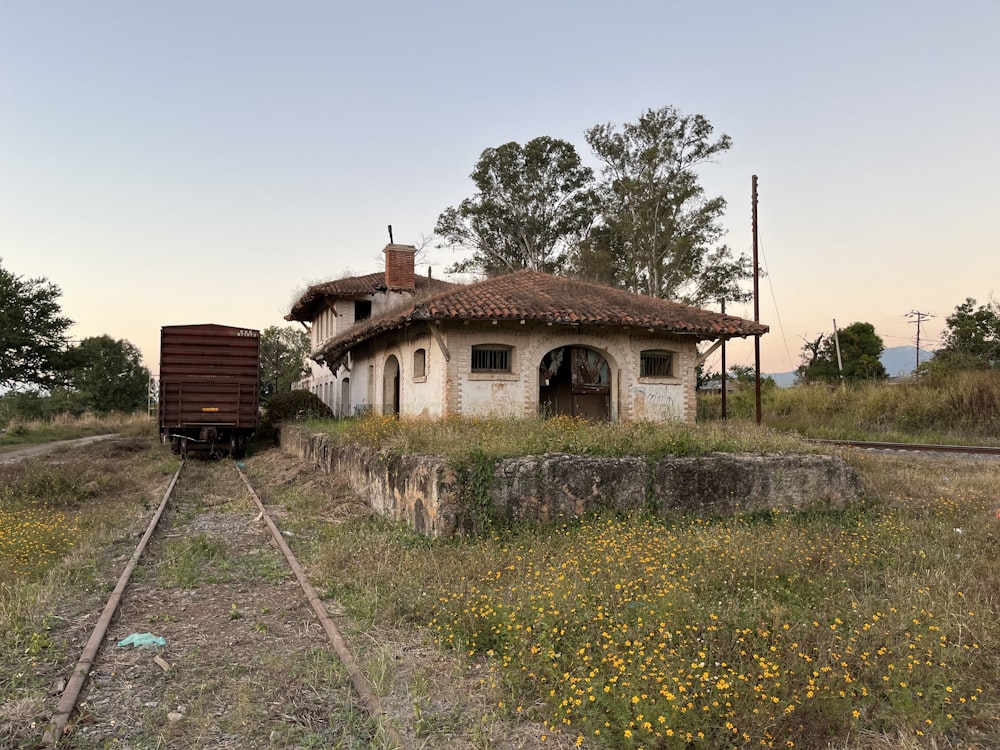 an old abandoned train station with a train on the tracks