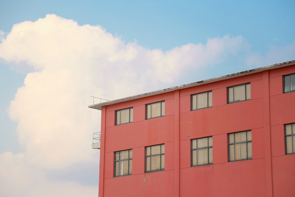 a red building with windows and a sky background