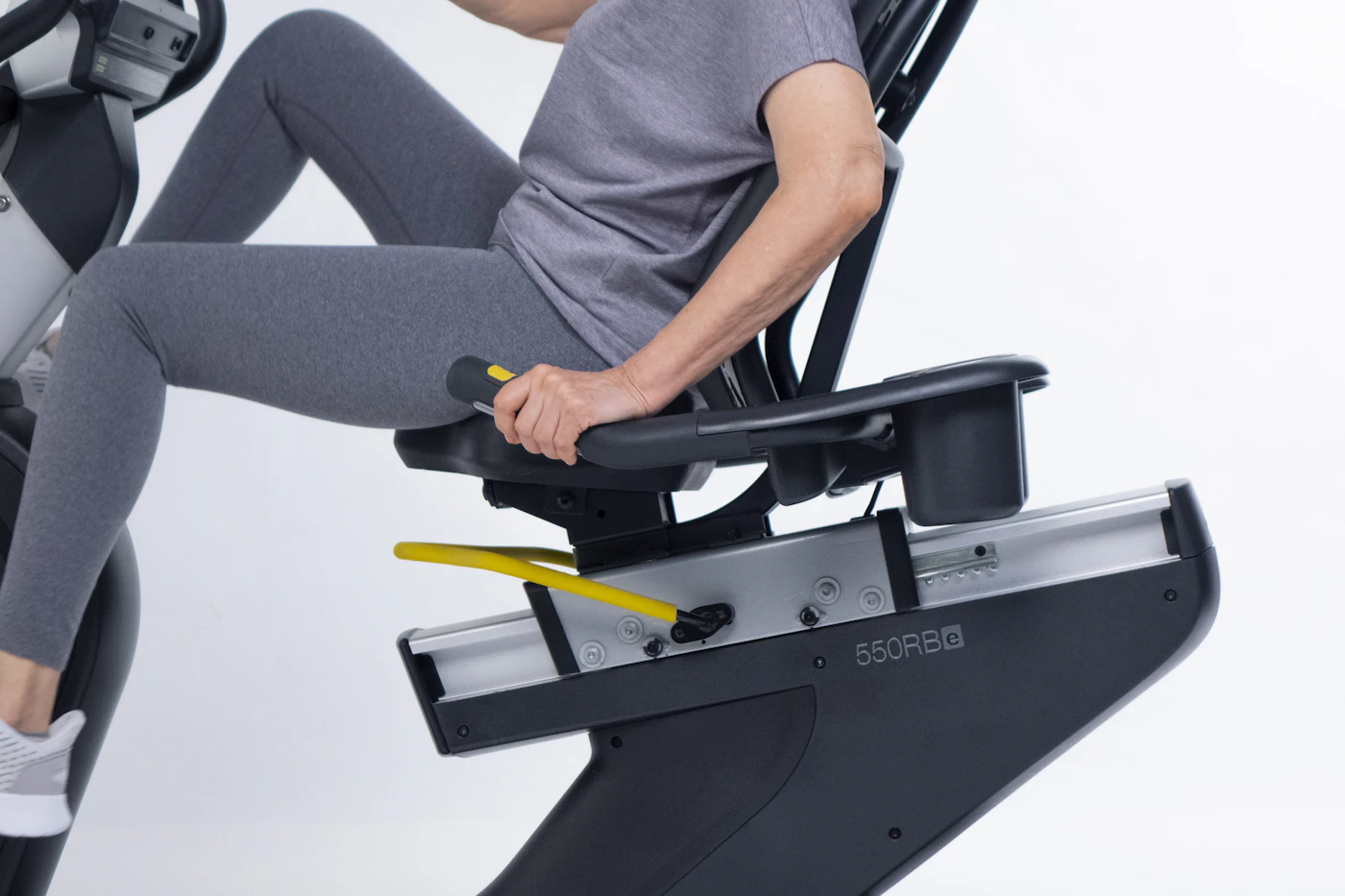 Adult exercising on a recumbent bicycle in a fitness facility
