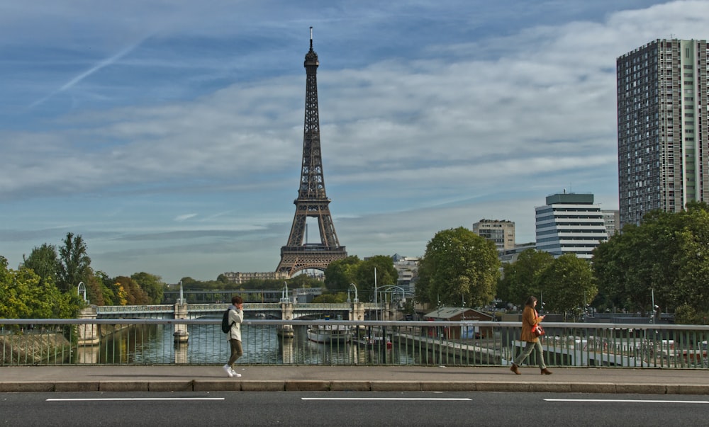 Un couple de personnes traversant un pont près de la Tour Eiffel