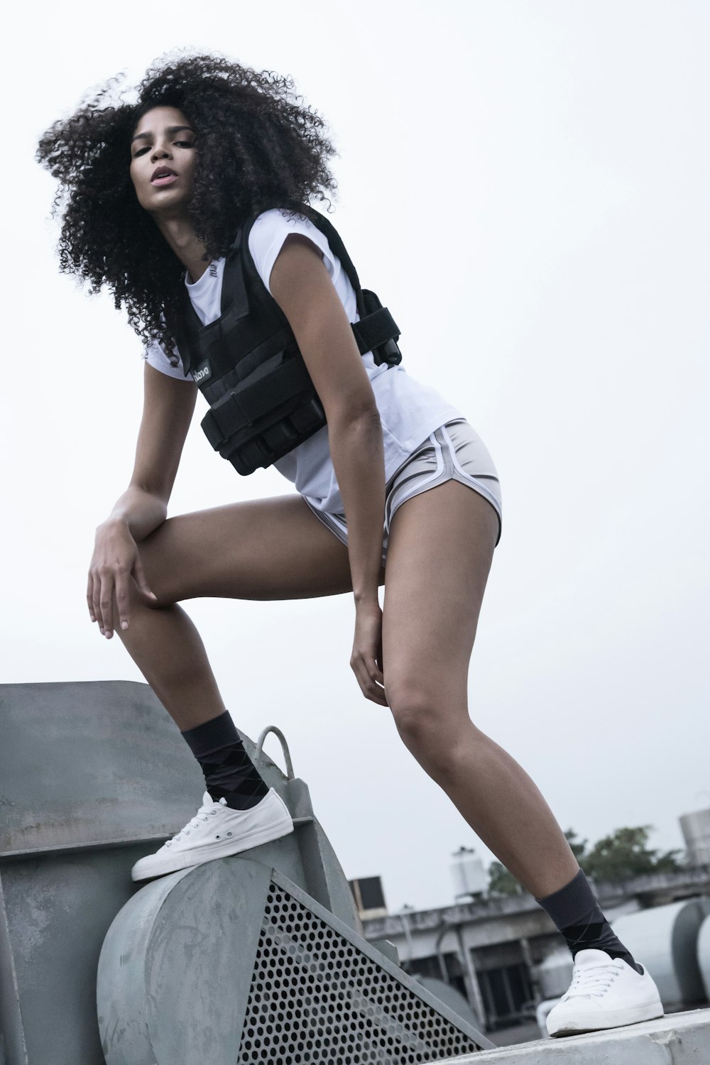 a woman with a back pack leaning on a metal object