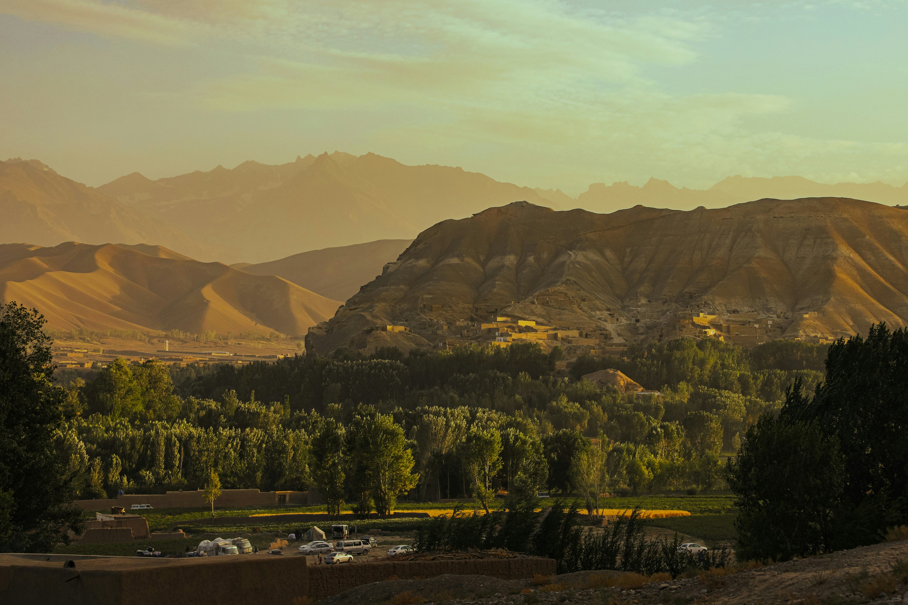 a scenic view of a valley with mountains in the background