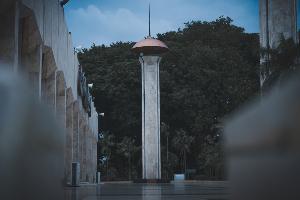 a tall clock tower sitting next to a forest